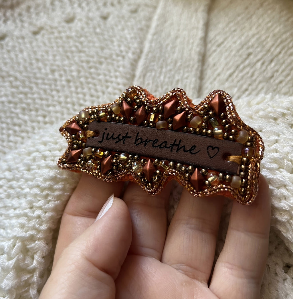 Broche en perles cuivrées à message en cuir gravé "Just breathe"
