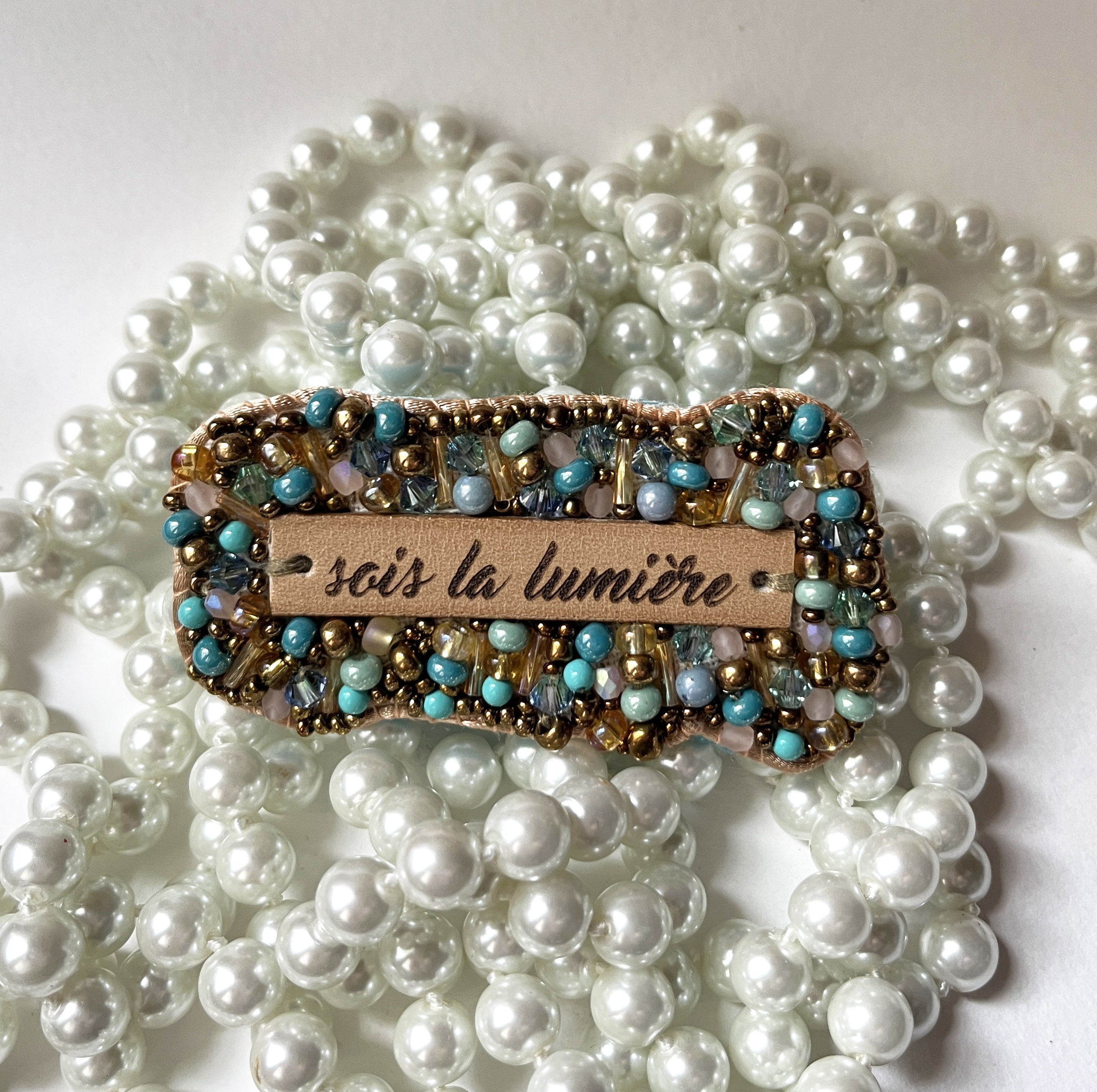 broche en perles tissées et message cuir