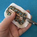 Broche en perles bleu turquoise au message en cuir gravé "Sois la lumière"