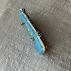 Broche en perles bleu turquoise au message en cuir gravé "Sois la lumière"