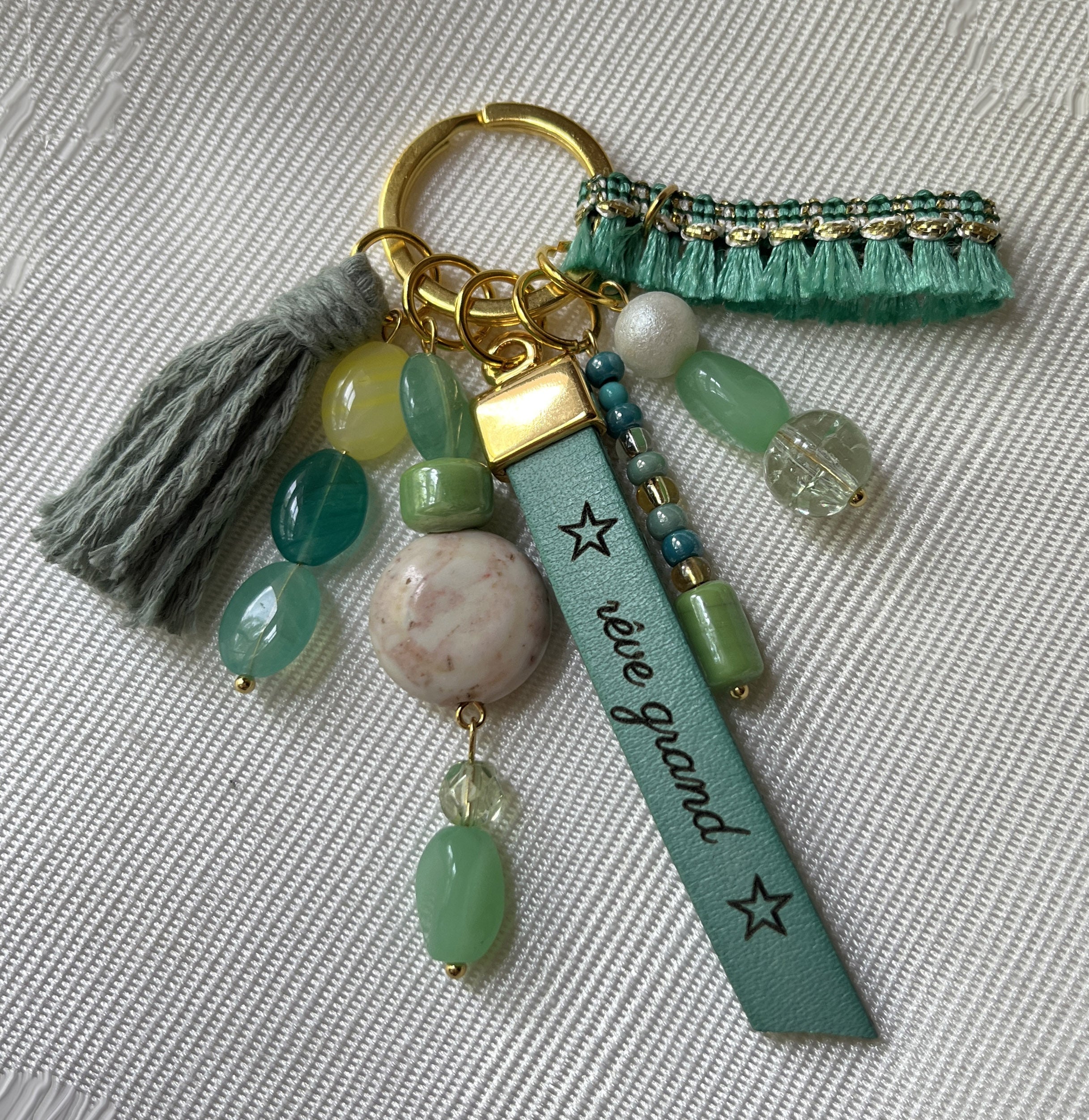Bijou de sac vert et doré multi breloques en perles et message cuir gravé