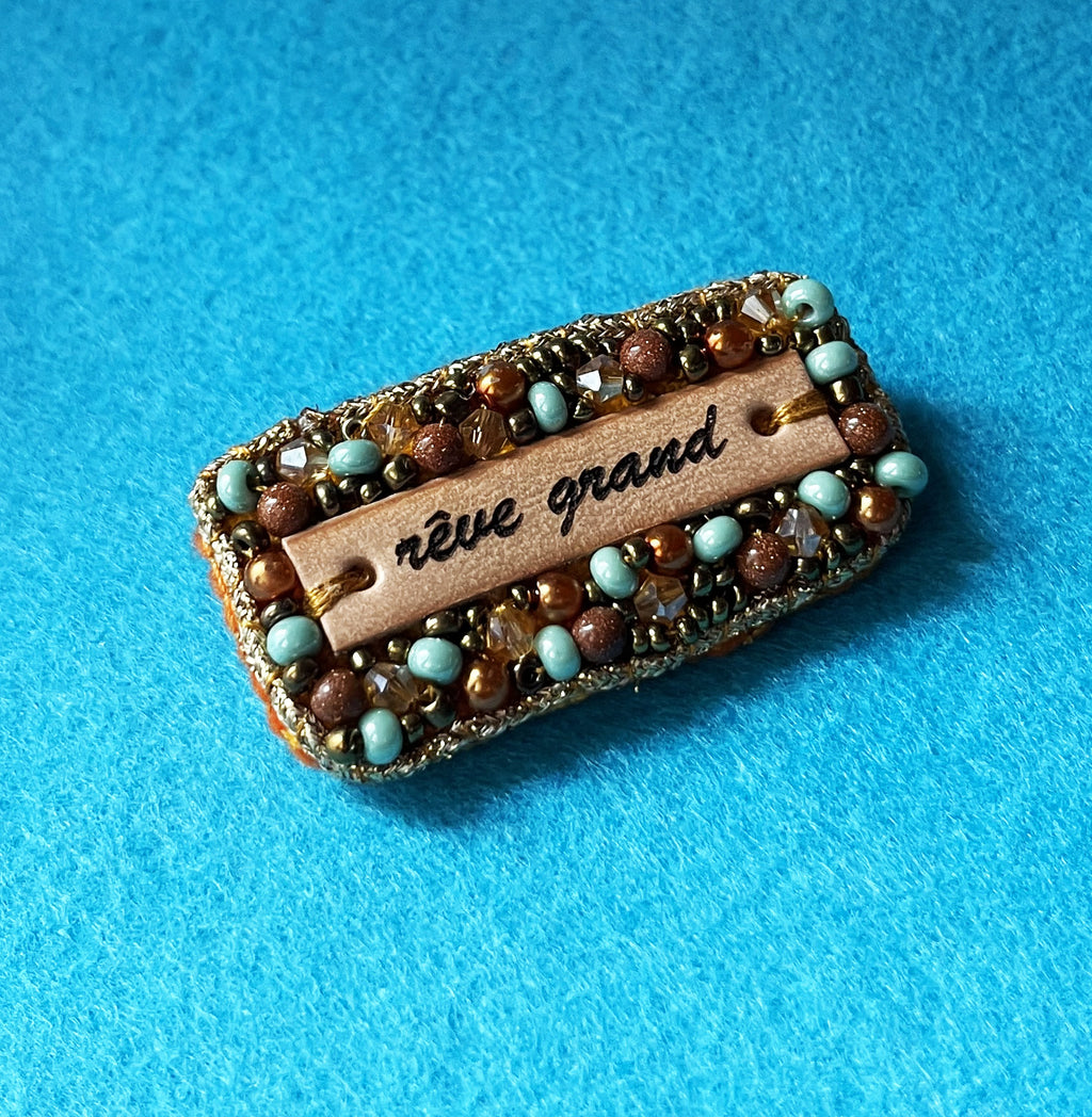 Broche à message en perles tissées et cuir gravé "rêve grand"