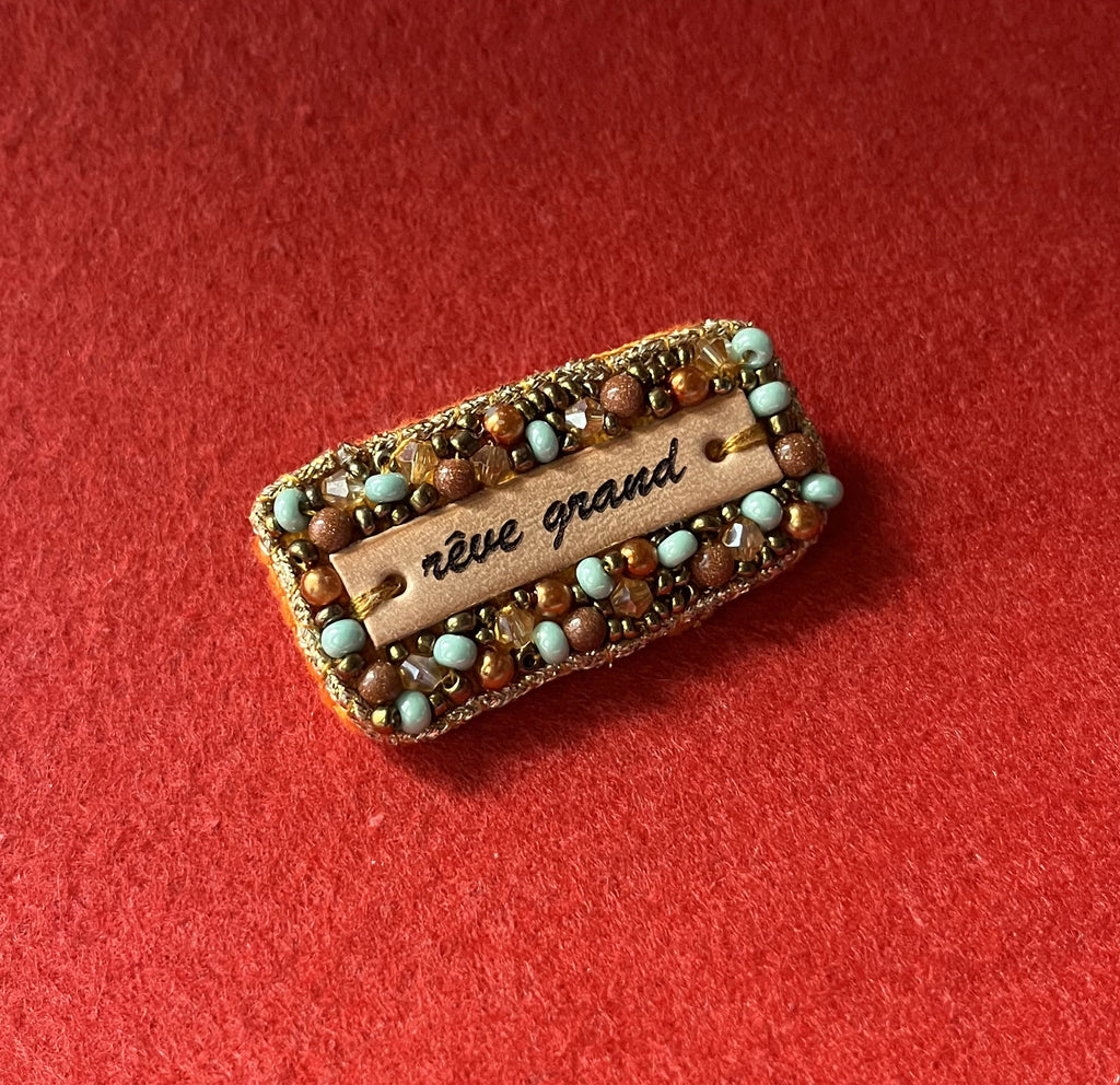 Broche à message en perles tissées et cuir gravé "rêve grand"
