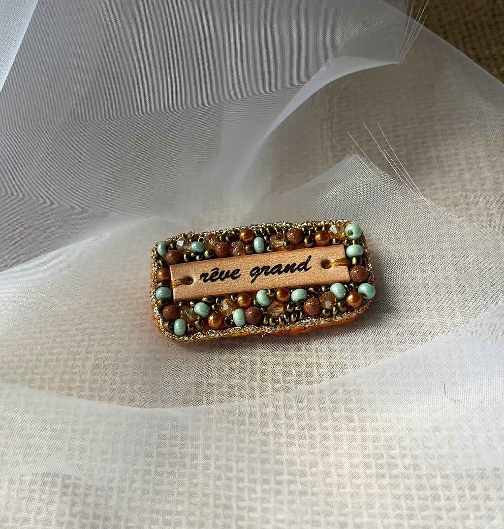 Broche à message en perles tissées et cuir gravé "rêve grand"